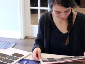 Customer looks at roof color options with shingle sample booklets