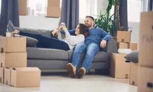 New homeowner couple on couch with moving boxes