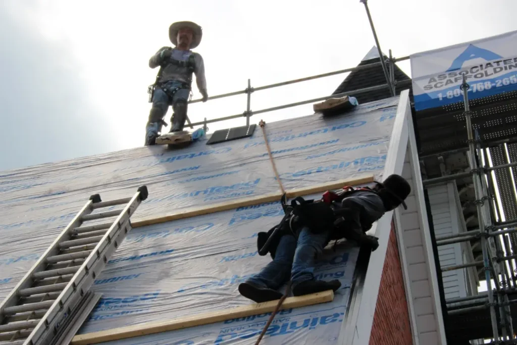 Close-up-roof-crew-on-top-steep-roof - Artisan Quality Roofing Close-up-roof-crew-on-top-steep-roof
