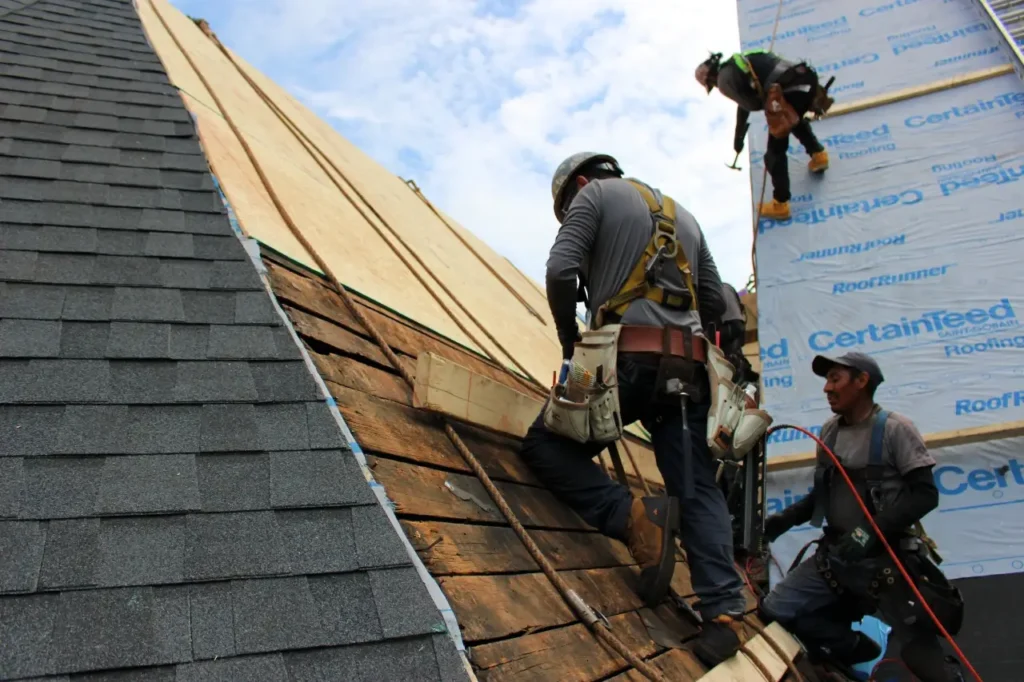 Roofing crew installs roof sheathing on church roof - Artisan Quality Roofing Roofing crew installs roof sheathing on church roof