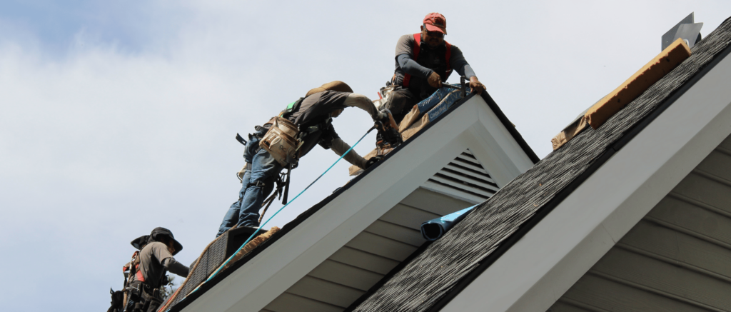 Roofing-crew-installs-final-shingles-on-gable-roof