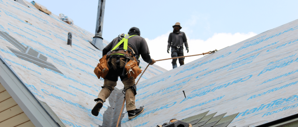 Roofing-tech-uses-harness-to-climb-up-roof-valley